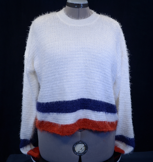 Woman's fuzzy white plush crewneck sweater with blue and red stripes on cuffs and bottom