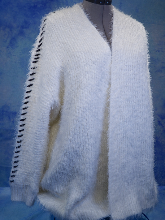 Woman's white eyelash open-front cardigan sweater with black hash marks along sleeves on dress form