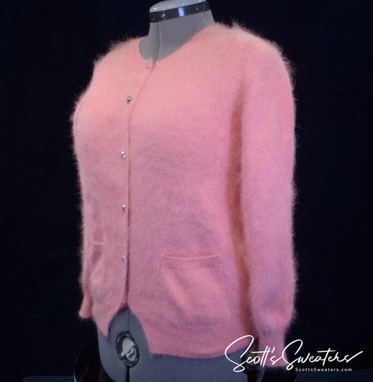 Woman's goth pink angora cardigan sweater with chrome skull buttons on mannequin
