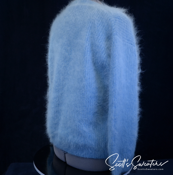 Woman's powder-blue angora cardigan sweater with oversized metal buttons and front pockets