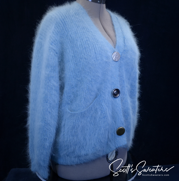 Woman's powder-blue angora cardigan sweater with oversized metal buttons and front pockets