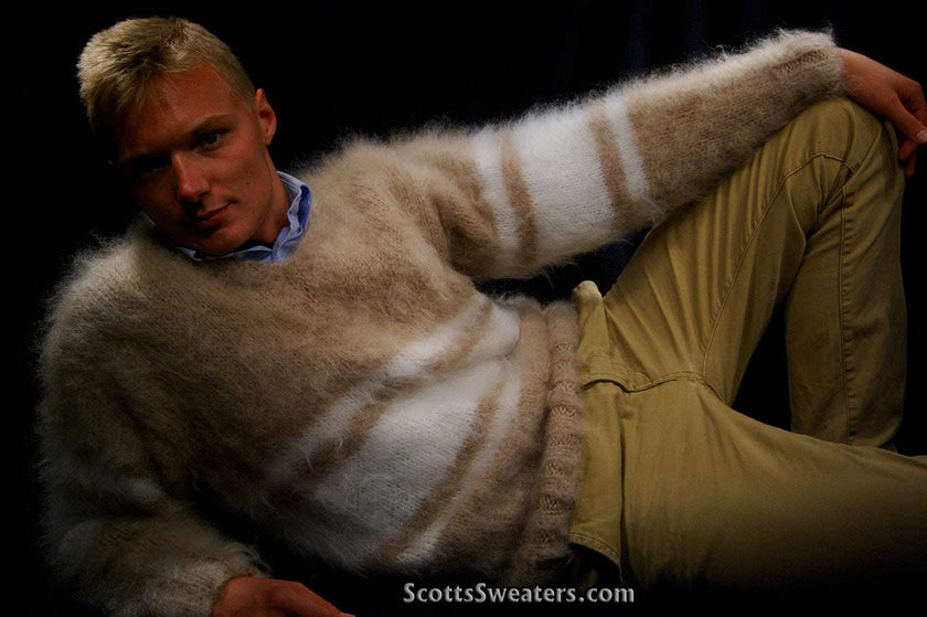 Man wearing extra soft hand-knit men's kid mohair sweater with beige and white stripes reclining against dark background