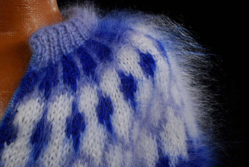 Close-up of hand-knit men's mohair cardigan sweater with blue and white fuzzy pattern and zipper front
