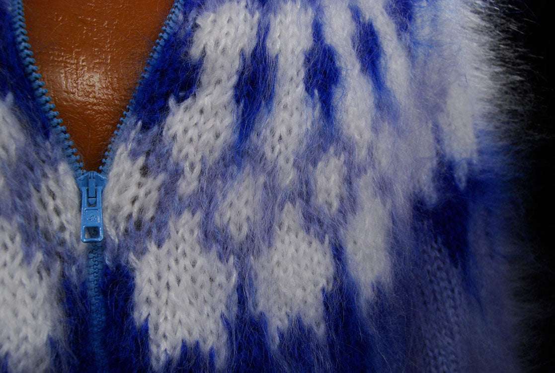 Close-up of hand-knit fuzzy mohair cardigan men's sweater with blue zipper and pattern