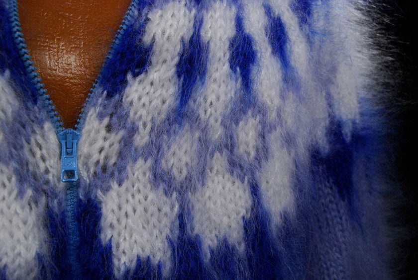 Close-up of hand-knit fuzzy mohair cardigan men's sweater with blue zipper and pattern