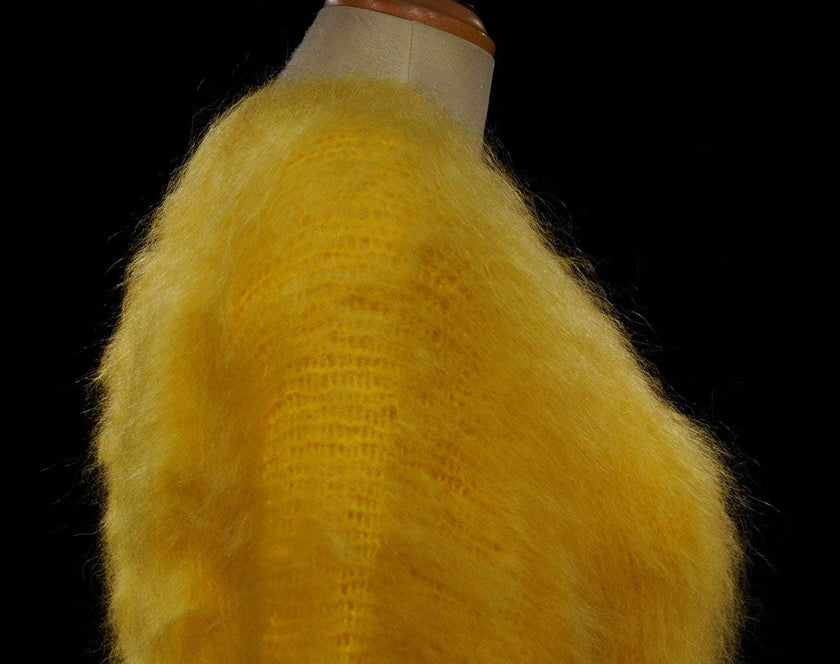 Woman's fuzzy yellow hand-knit mohair sweater with double V-neck design on a mannequin