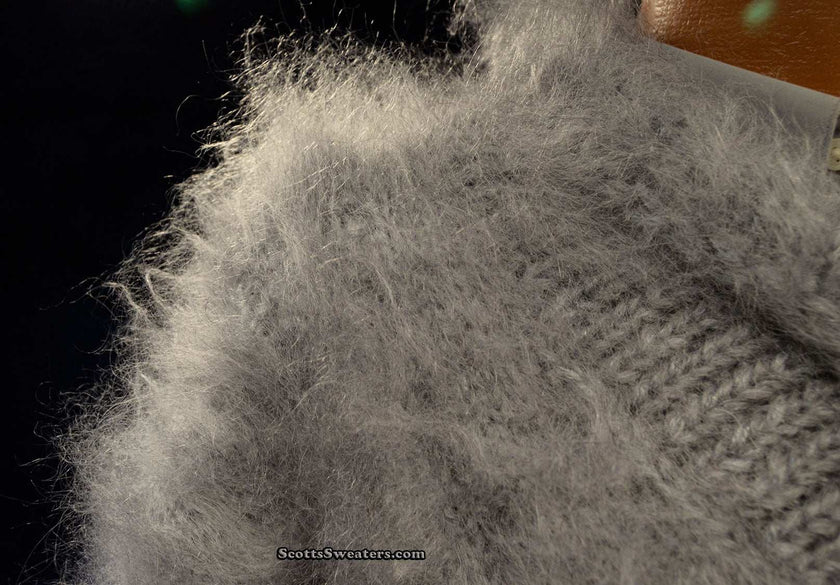 Close-up of soft gray hand-knit mohair sweater with fluffy texture and cross-over neck design