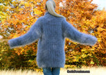 Back view of person wearing hand-knit unisex blue mohair sweater with cross-over neck in autumn setting