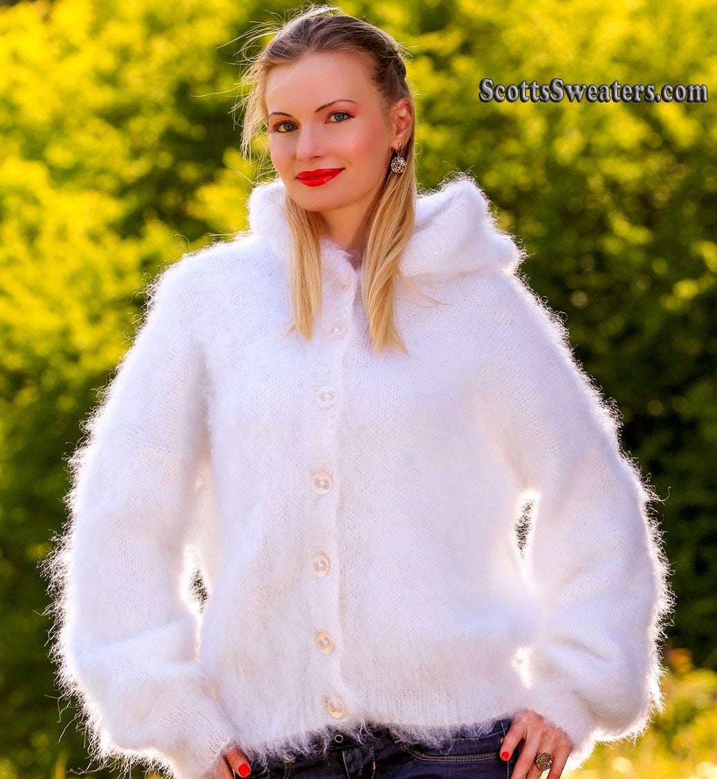 Woman wearing a white hand-knit mohair sweater jacket with hood and buttons outdoors