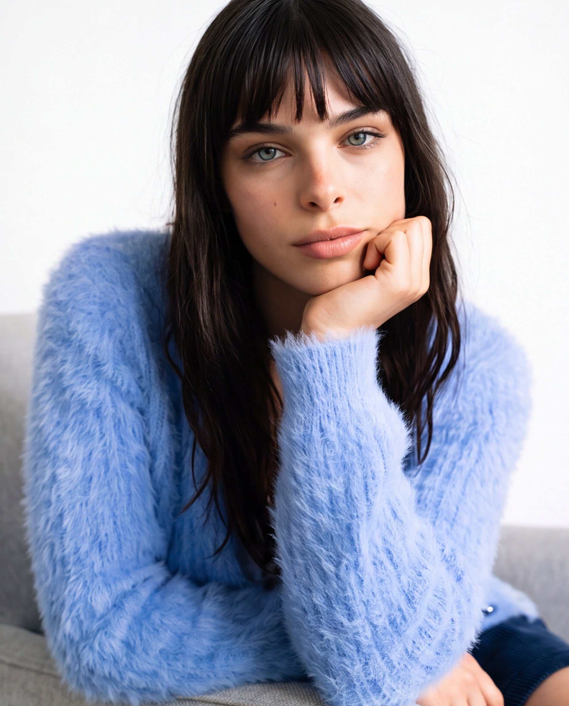 Woman wearing a woman's powder-blue angora cardigan sweater with pockets, showcasing soft, cozy fabric and elegant style